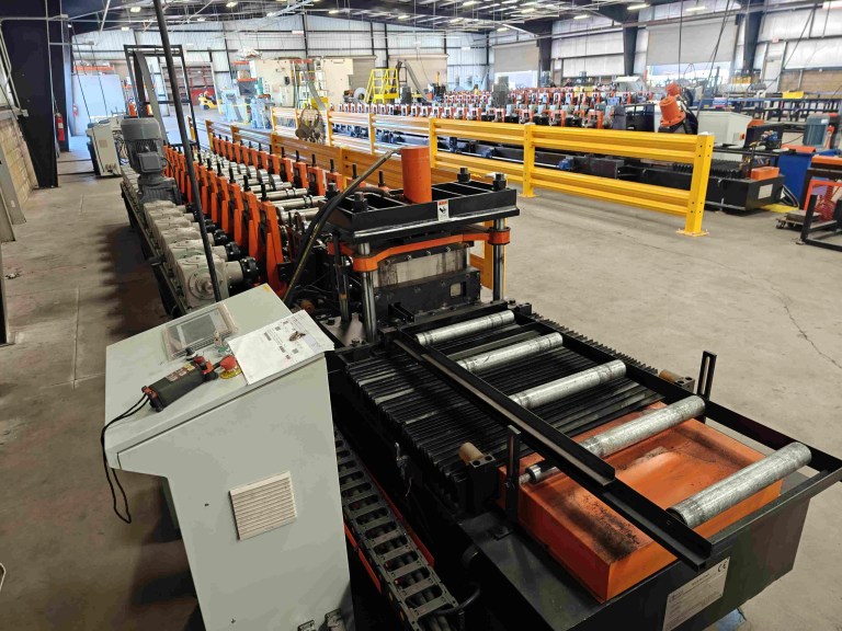 The flying hydraulic cutting mechanism positioned at the end of the roll forming line. A powerful hydraulic shear is mounted on a moving carriage to cut the formed profile to length without stopping the forming process.