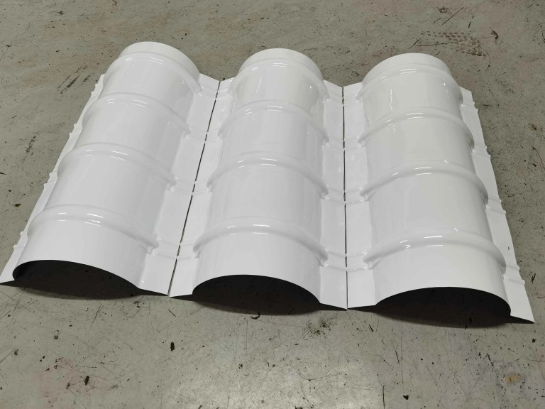 Amostra de cumeeira de telha acabada com superfície texturizada, combinando com os perfis das telhas para uma vedação perfeita do topo do telhado.